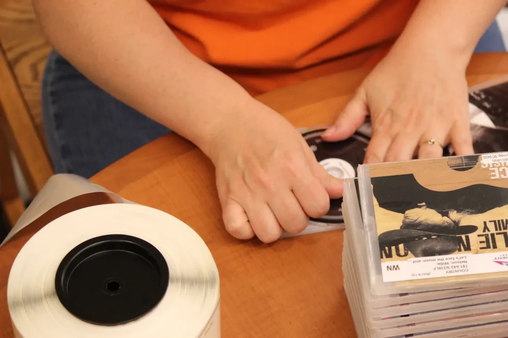 Staff member applying RFID tags to library media at Mid-Continent Public Library