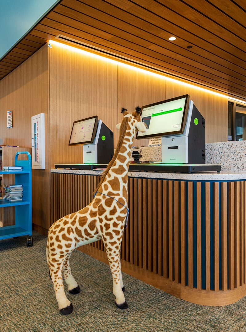 Giraffe feature next to self-service kiosk at Belmont Public Library