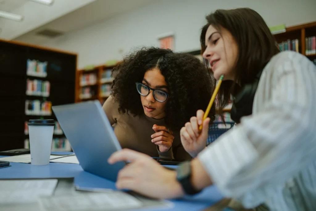 Library users working together on a laptop, reflecting how AI is being explored in everyday library workflows