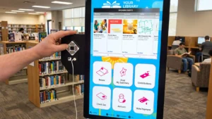 Library user navigating an accessible self-service kiosk with AudioNav controls