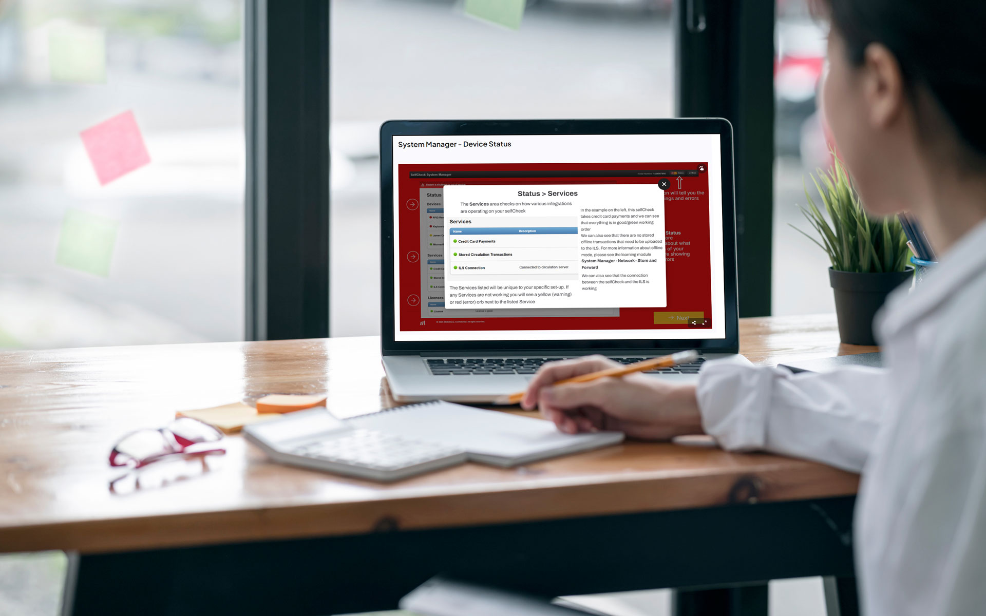 Library staff member using Bibliotheca Academy training platform on a laptop