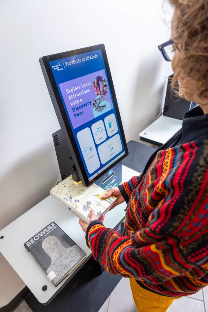 Patron uses the Bibliotheca selfCheck 3000 kiosk in Spanish at Cincinnati Public Library.