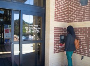 Mulher usando o painel open+ access para entrar na biblioteca pública de Gwinnett County