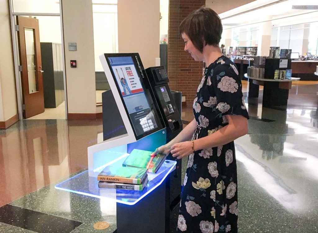 Lady using the selCheck 1000 in fayetteville public library