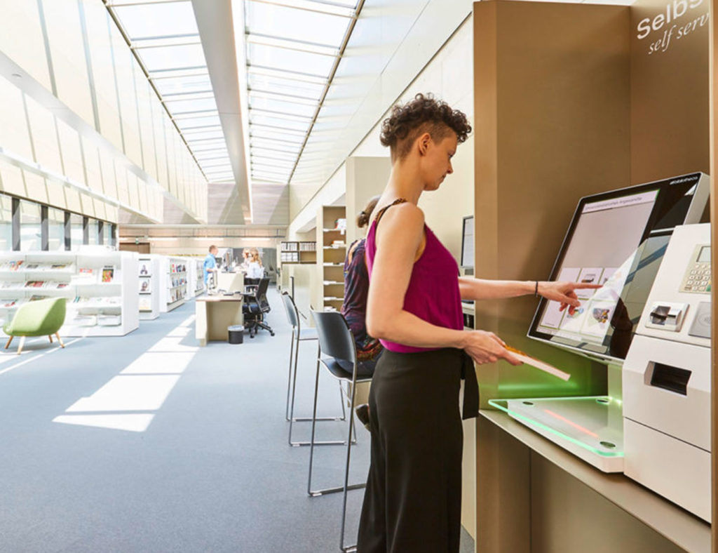 Lady using the selfcheck 1000D in Vienna University library