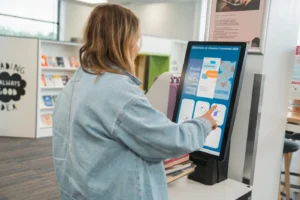 Library patron using a selfCheck station with quickConnect to view programs and services