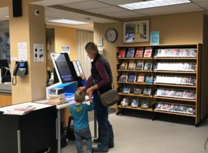 Mother and son checking out books at the selfCheck 1000 in Hamilton library