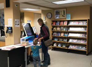 Mother and son checking out books at the selfcheck 1000 in hamilton library