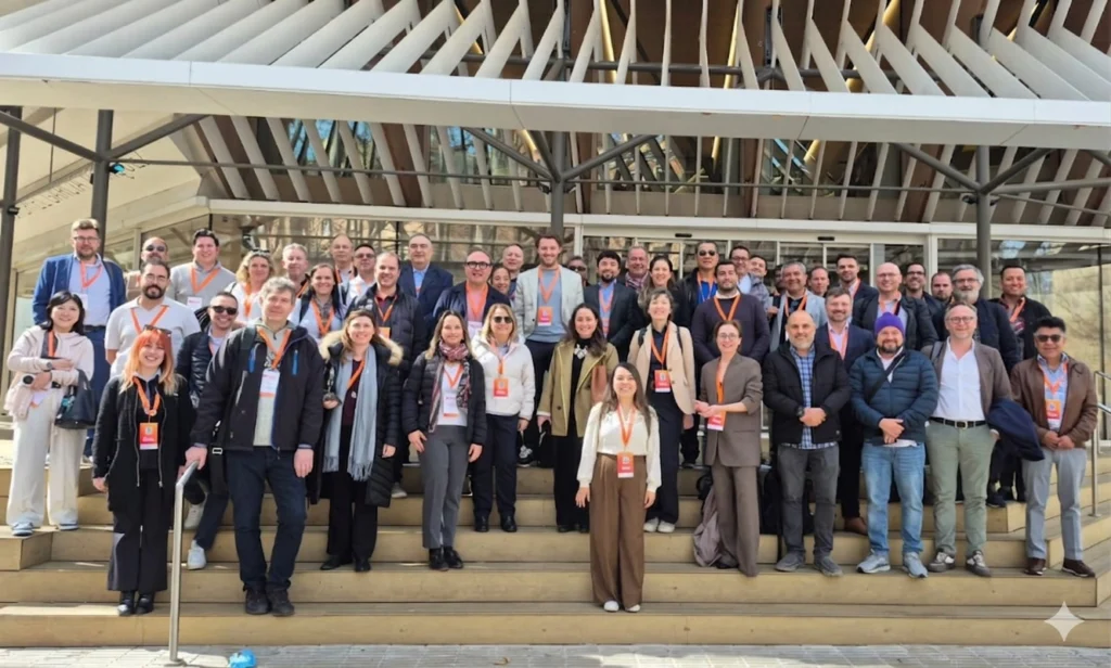 A large group of international business partners poses for a group photo in front of the Gabriel García Márquez Library in Barcelona, during the Partner Summit ON AIR 2026 event.