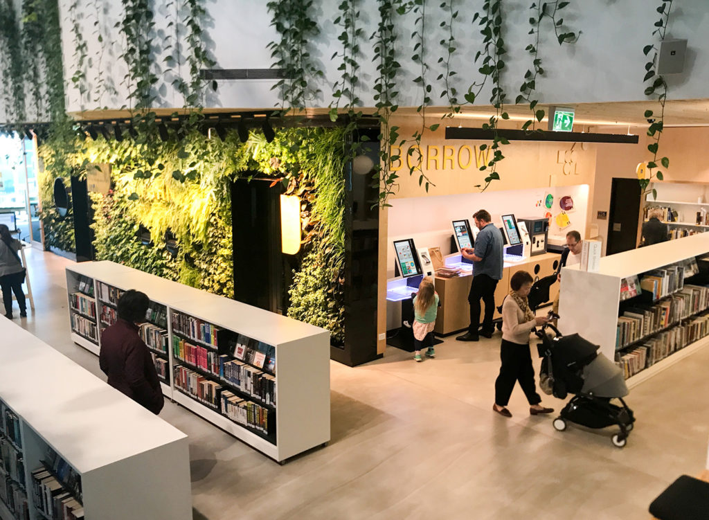 selfCheck1000 na biblioteca com parede de folhas e tema de selva ao ar livre