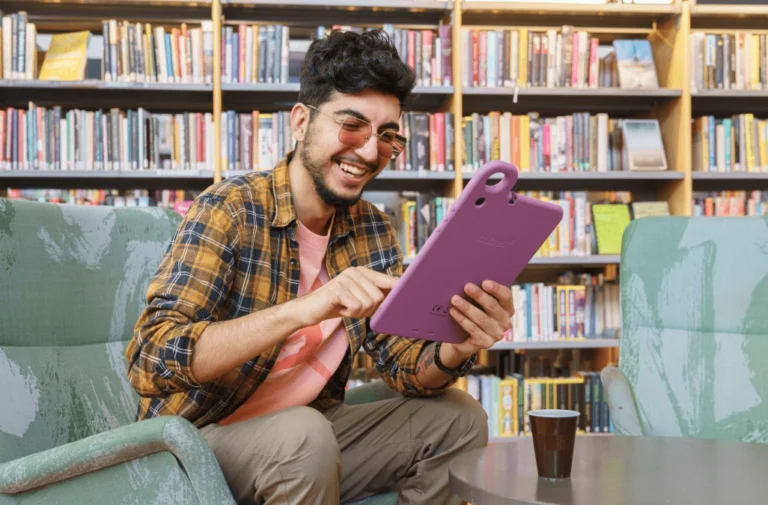 Como modernizar sua biblioteca com empréstimo inteligente de tablets 3 Usuário utilizando tablet emprestado pelo Hublet para acessar conteúdos digitais em uma biblioteca.