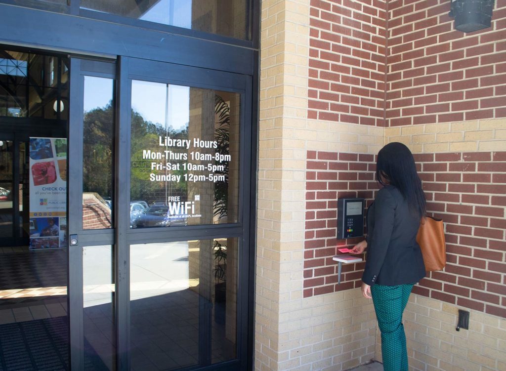 Woman scanning library card to access open+ library