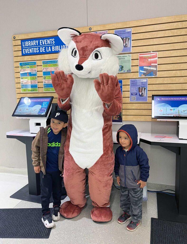 Expansive community reach: Aurora Public Library District 6 aurora-library-mascot-and-children