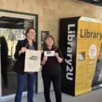 Librarians holding items in front of Blue Mountains Library remoteLocker.