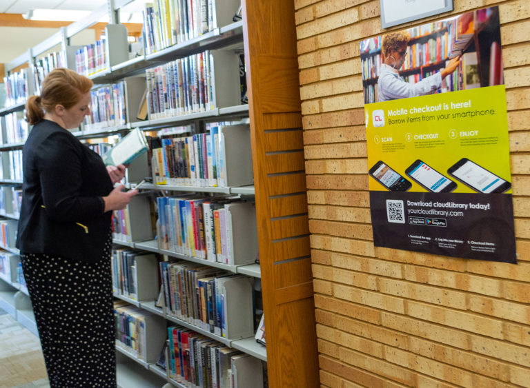 Plakat med markedsføringsmaterialer fra cloudLibrary på biblioteksvæg