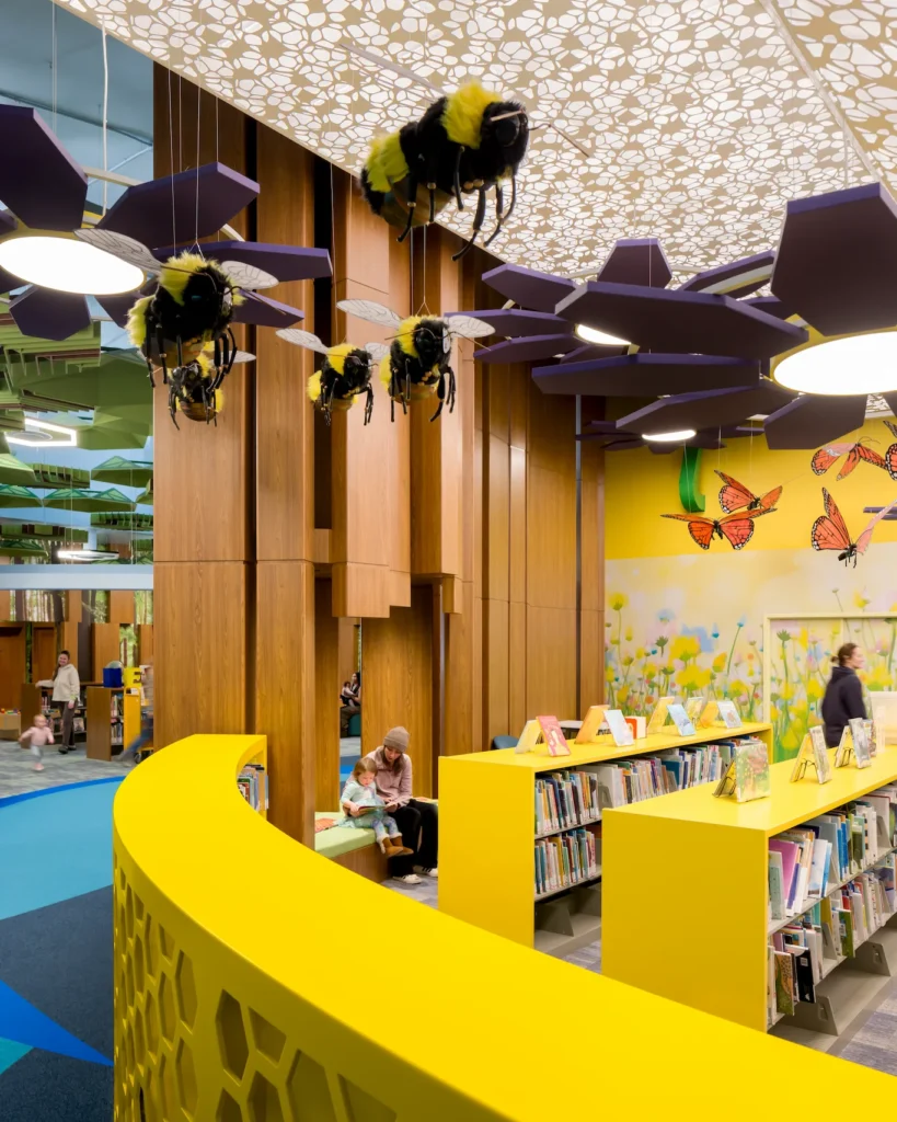 selfCheck + integrated return bins for service-centric success: Redford Township District Library 6 Children's library area with bee and butterfly decor at Redford Township District Library.