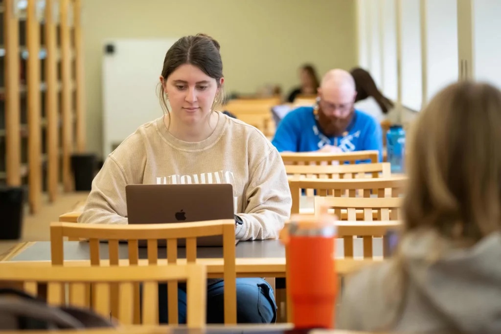 Students studying with laptops inside University of Wyoming Libraries