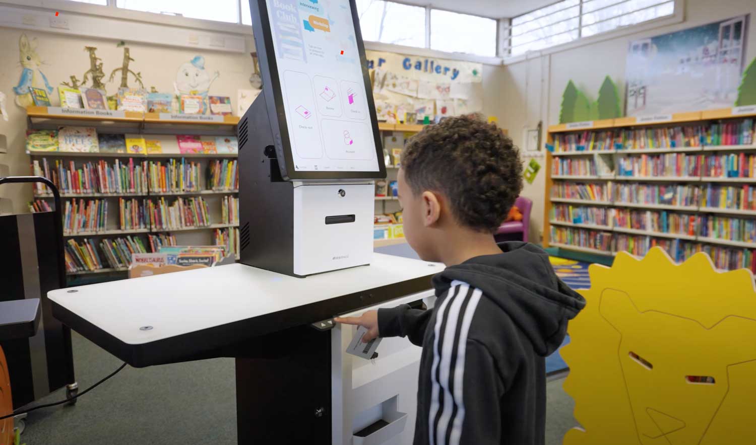 Brisbane City Council Libraries: Meeting evolving needs with library innovation 2 young boy lowering the selfCheck 3000 adjustable leg | Brisbane City Council Libraries: Meeting evolving needs with library innovation
